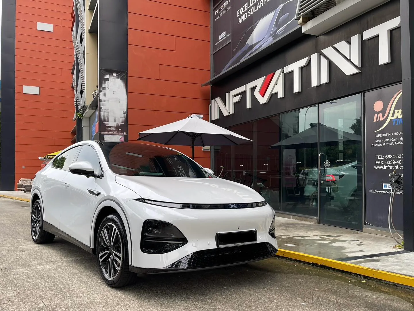 White XPENG G6 front three-quarter view outside Infratint Singapore