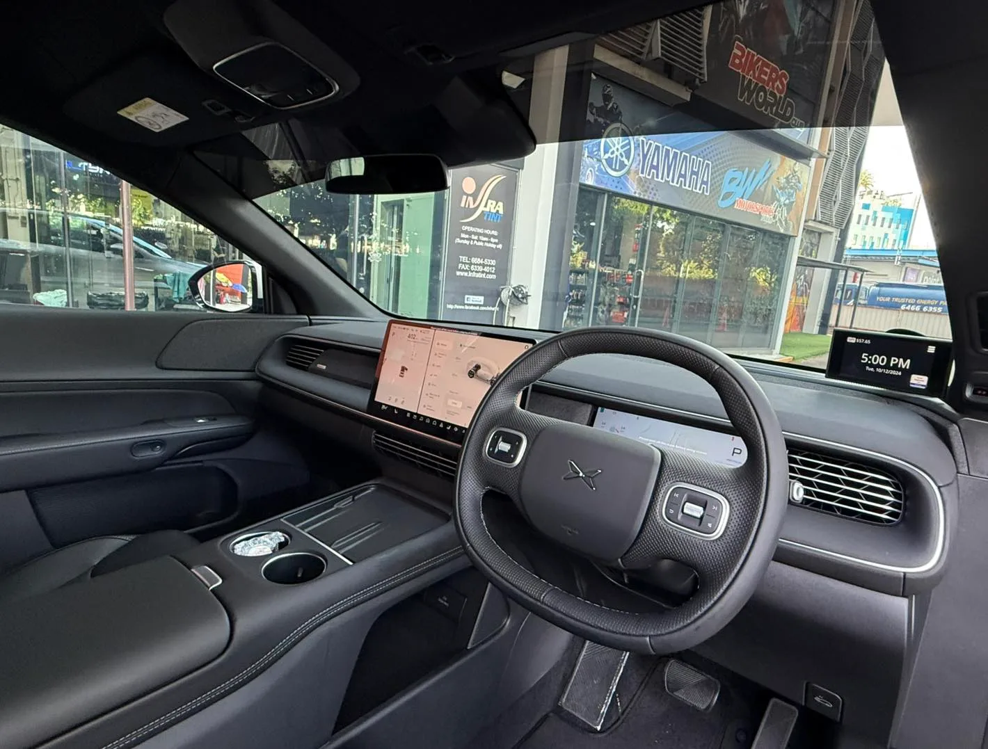 XPENG G6 interior with central touchscreen seen through tinted glass at Infratint Singapore